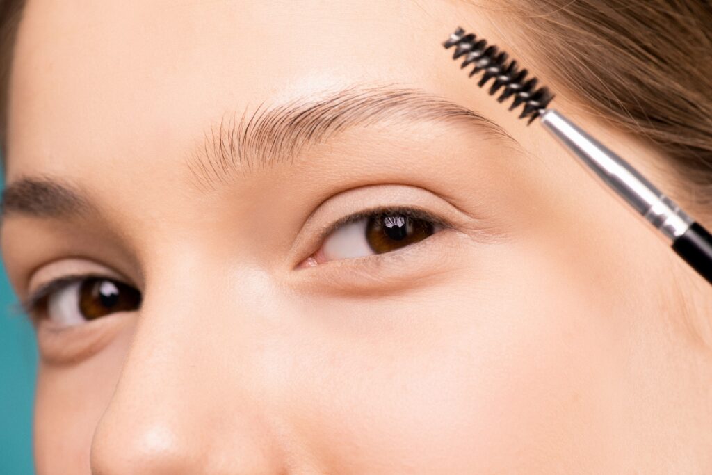 Aluna assistindo a um curso de Brow Lamination e Lash Lifting online em um tablet com materiais de estética ao lado.